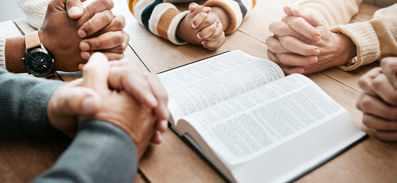 Familles et croyants réunis autour d’une Bible ouverte pour un temps de prière et d’étude biblique à l’Église Action Biblique Vevey-La Riviera.