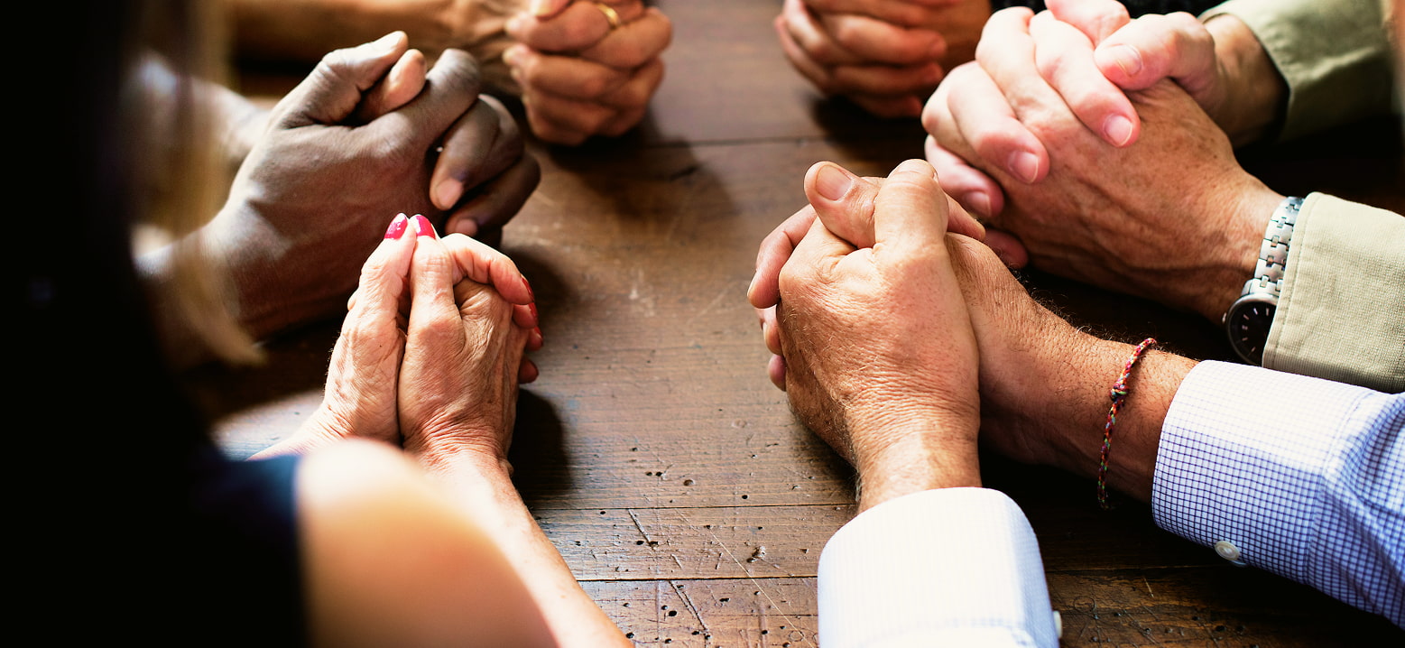 Membres de l’Église Action Biblique Riviera réunis dans la prière, symbole du soutien et de l’engagement envers la mission de l’Église.